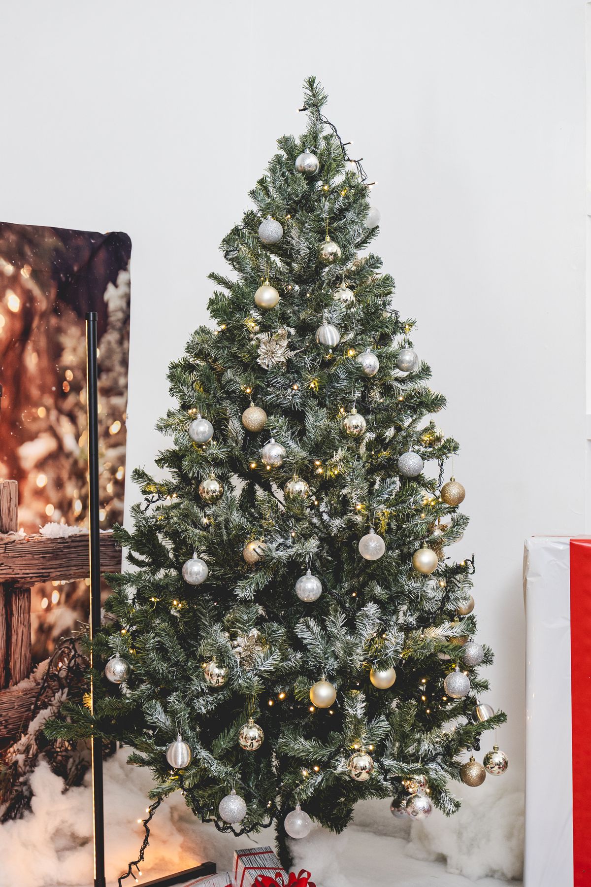 Christmas tree with gold and silver ornaments and warm lights