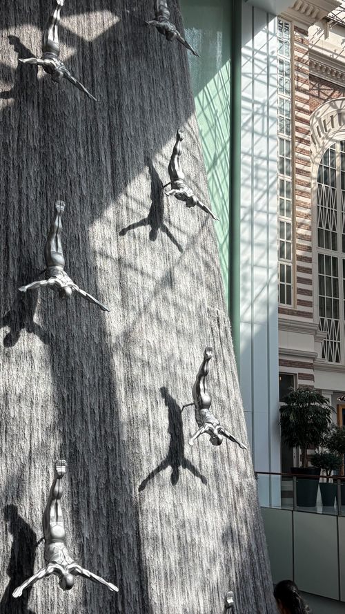 Free Stunning indoor waterfall featuring diver sculptures in a modern architectural setting. Stock Photo