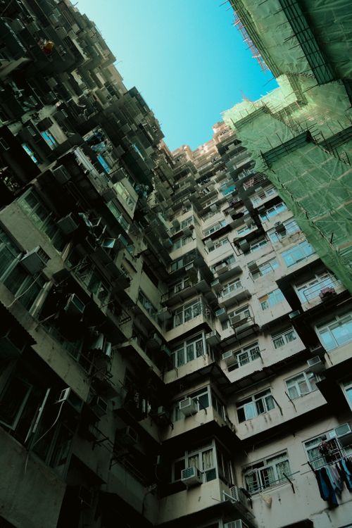 Free A view looking up at densely packed apartment buildings in Hong Kong's urban landscape. Stock Photo