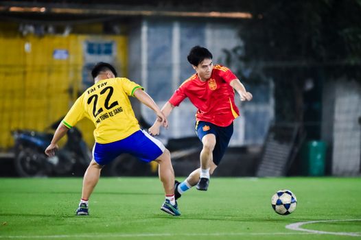 Two young adults playing an intense game of soccer on an outdoor field, showcasing athleticism.