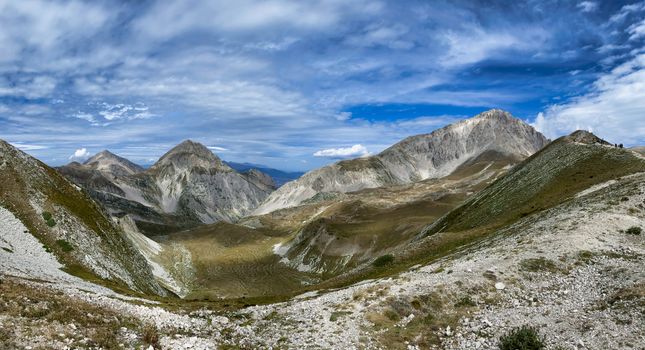 Scenic view of the Gran Sasso mountains in Abruzzo, Italy with a clear blue sky and rugged terrain.
