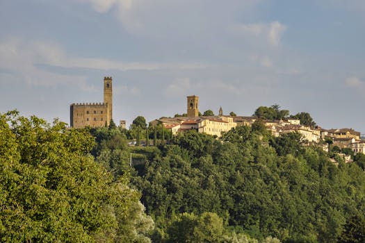 Beautiful view of Poppi Castle and lush green landscape in Tuscany, under a clear blue sky.