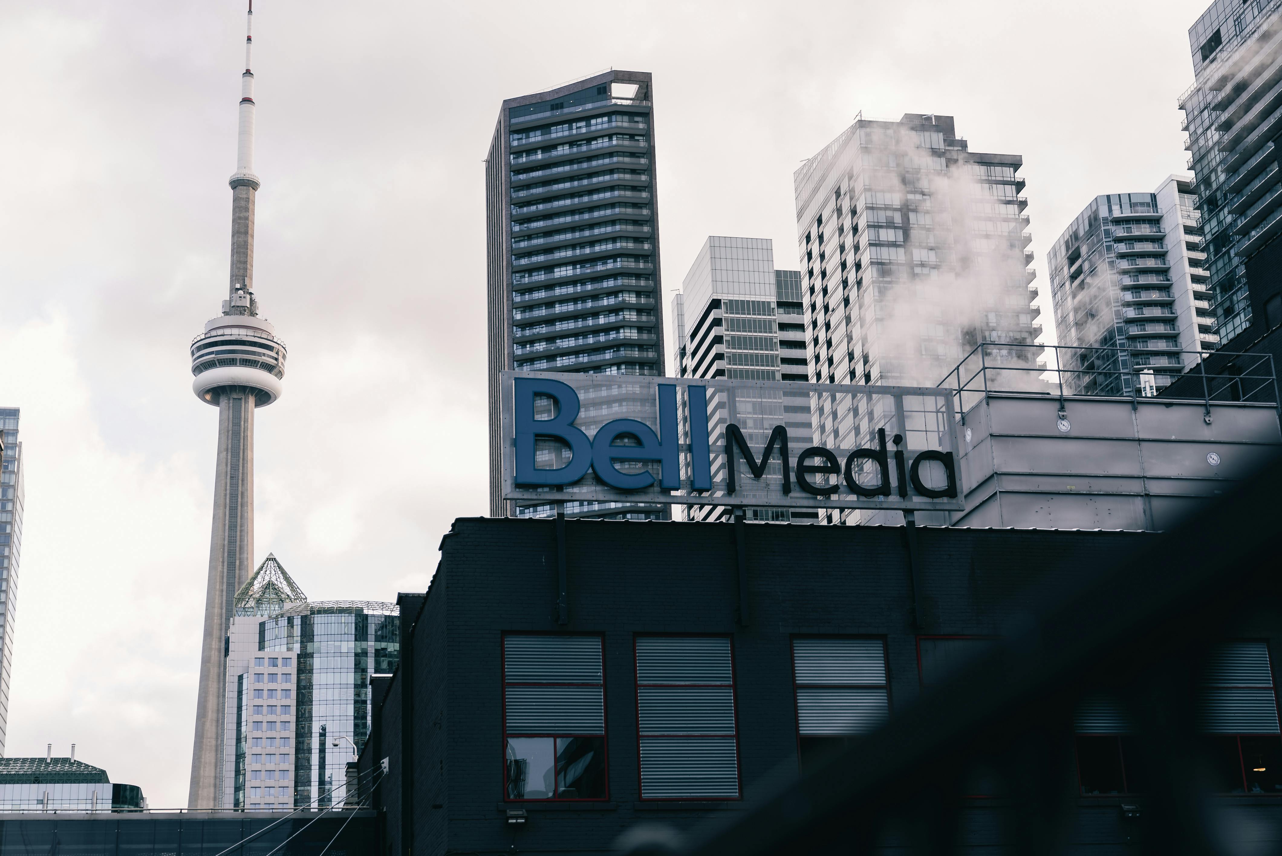 Toronto cityscape with CN Tower and Bell Media building, a blend of modern architecture.