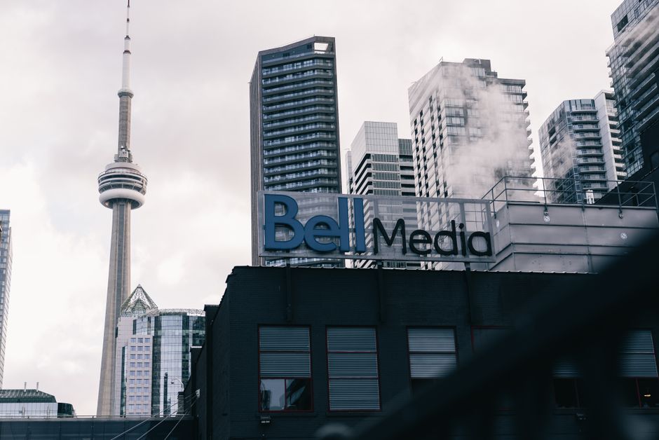 Toronto cityscape with CN Tower and Bell Media building, a blend of modern architecture.