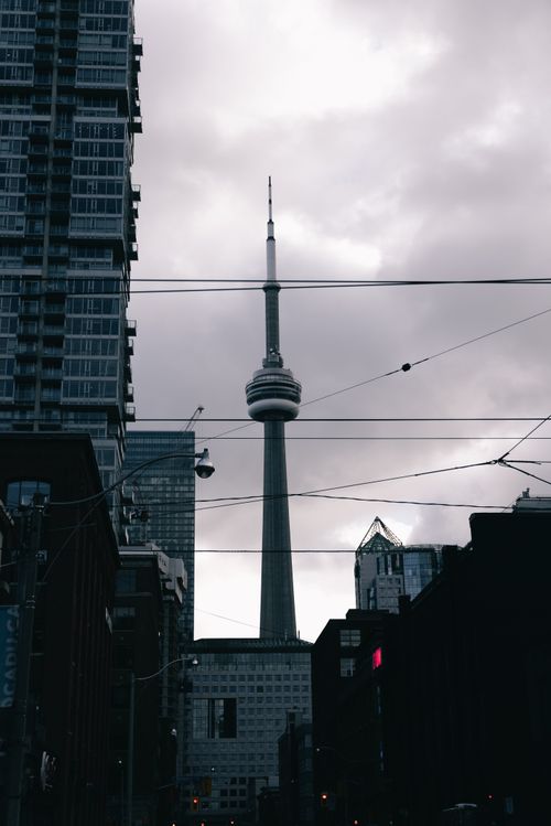 Free The CN Tower rises prominently against a cloudy evening sky in Toronto's cityscape. Stock Photo