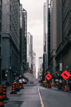 Urban downtown scene with construction and steam on a city street.