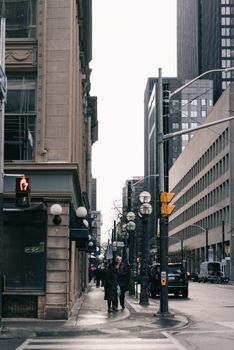 Moody urban street view in a modern downtown with pedestrians and high-rise buildings.