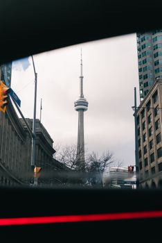 A striking view of the CN Tower framed by skyscrapers in Toronto's urban landscape.