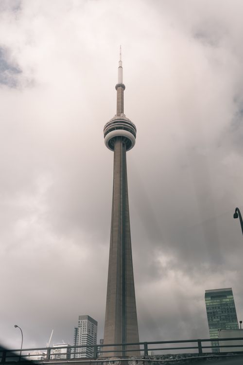 Free The CN Tower in Toronto reaching into a cloudy sky, showcasing its architectural magnificence. Stock Photo