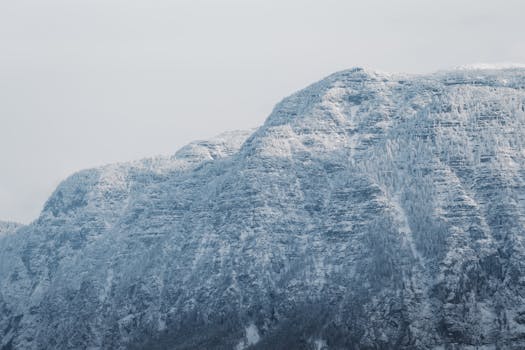 A stunning image of frosty, snow-covered mountain cliffs under a clear winter sky.