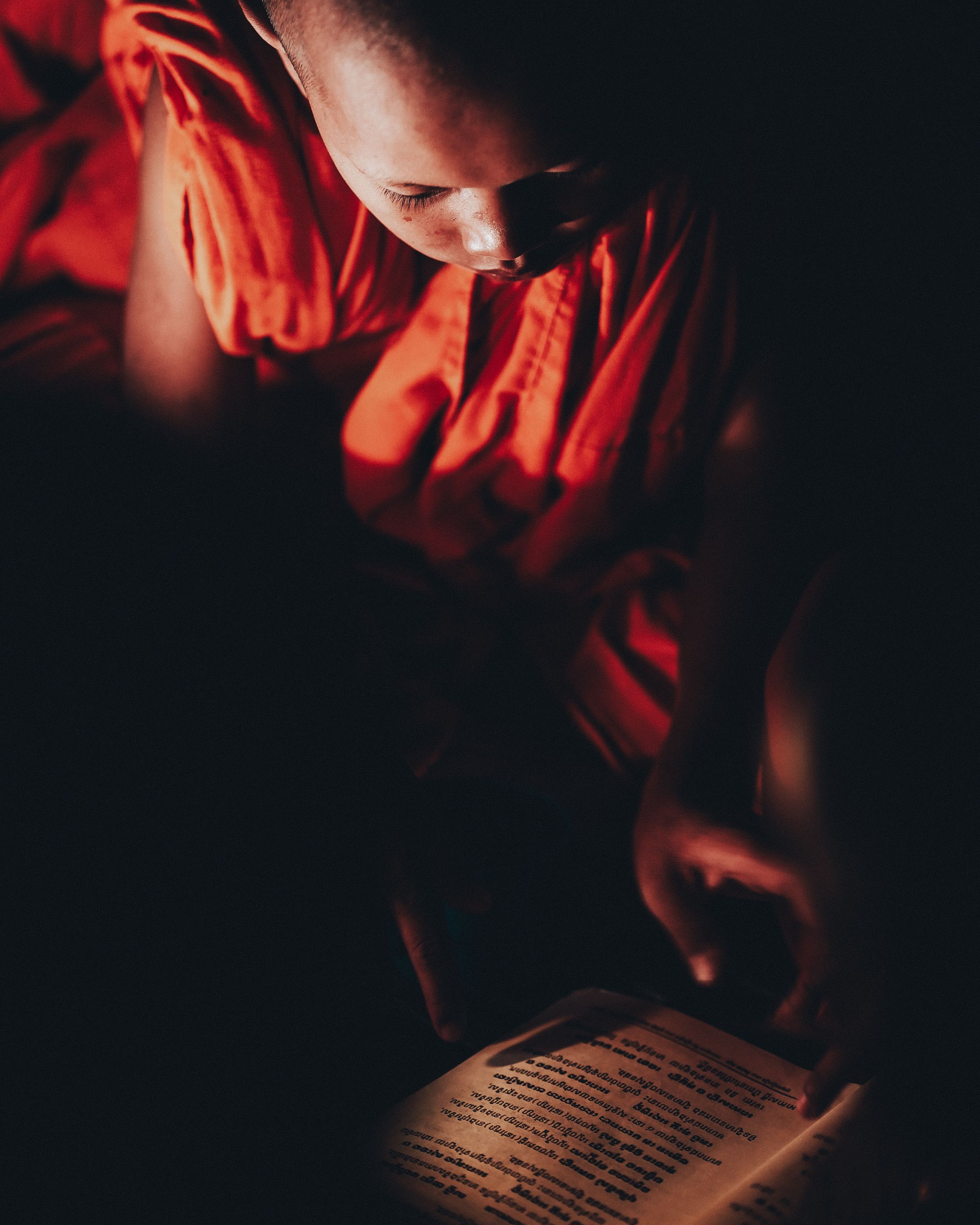 Young Monk Reading Sacred Text by Candlelight · Free Stock Photo