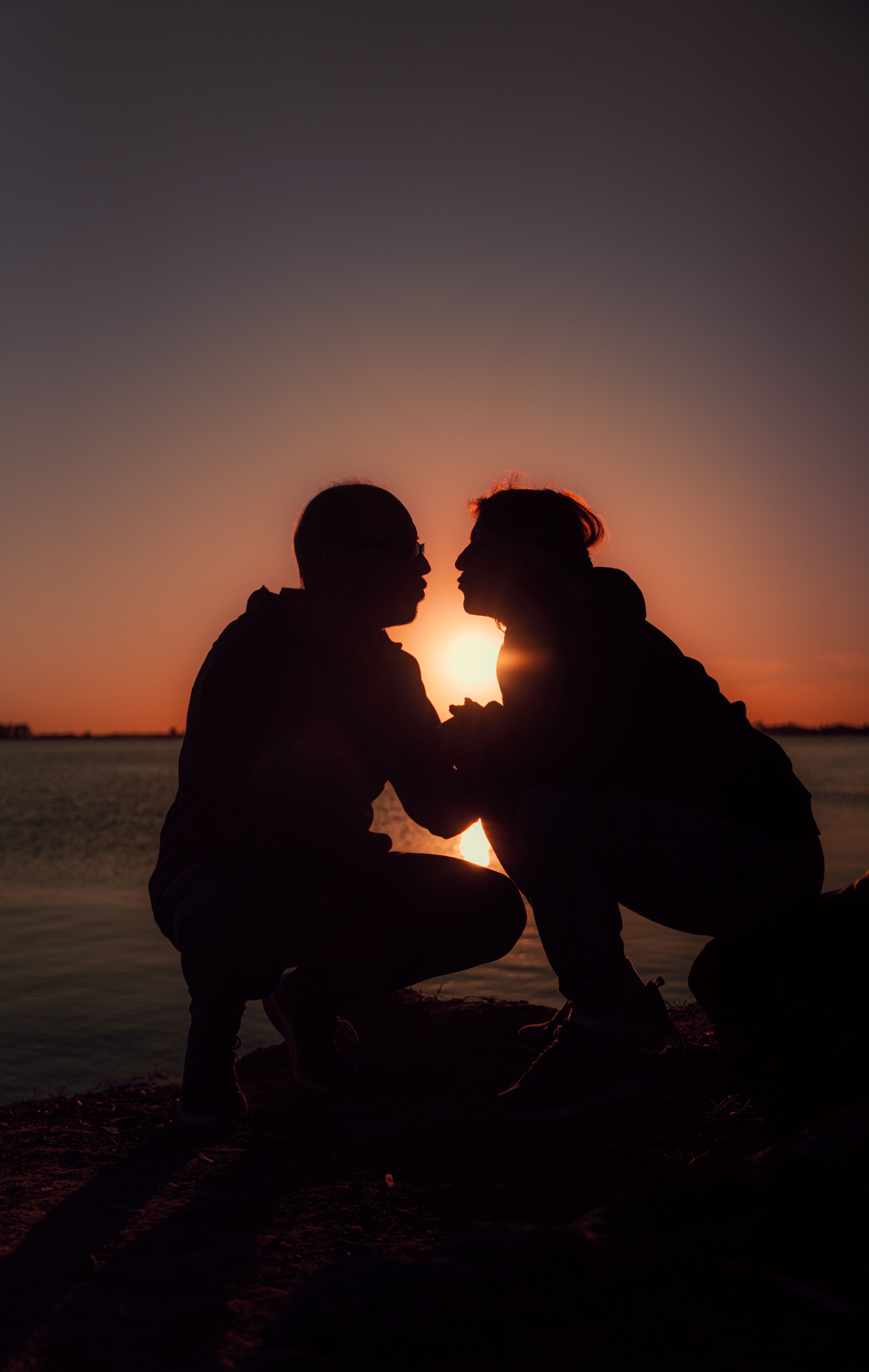 Silhouetted Couple at Sunset by the Lake · Free Stock Photo