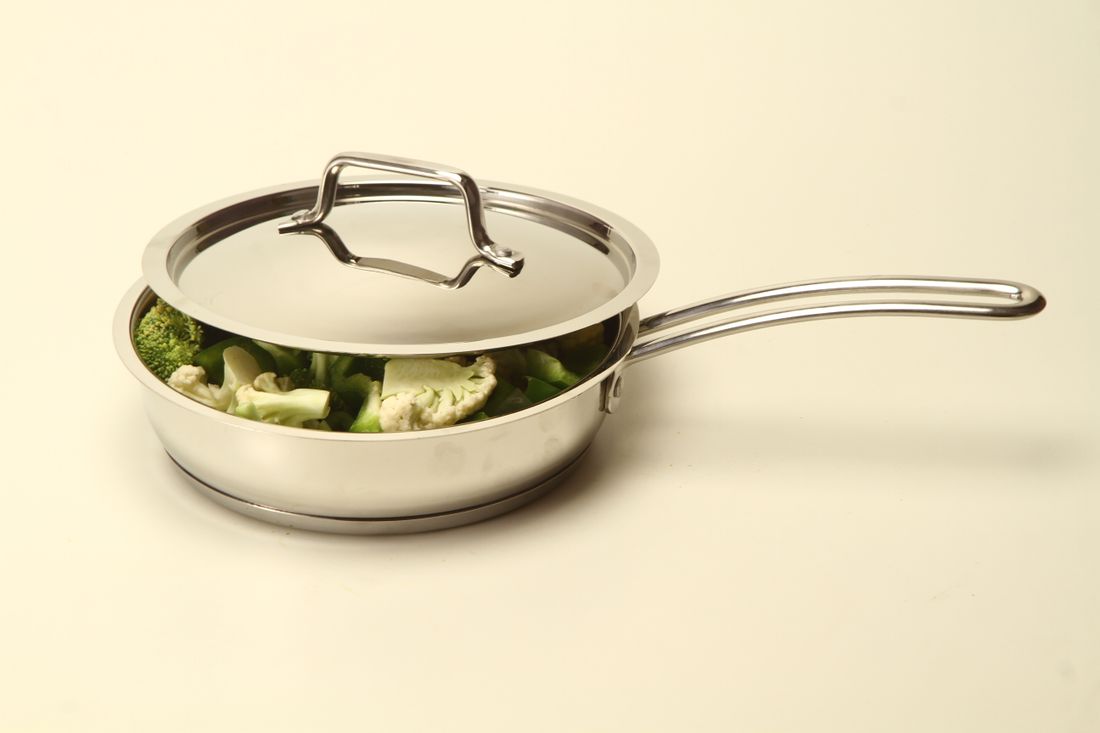 Stainless steel saute pan with lid holding broccoli and cauliflower florets