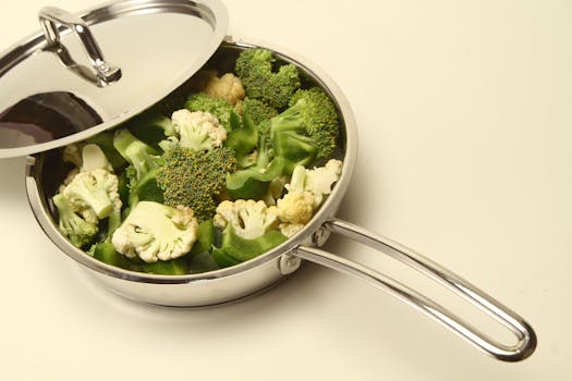High-angle view of broccoli and cauliflower in a stainless steel pan, perfect for healthy cooking inspiration.