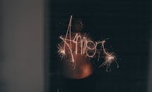 烟花手在黑暗中写下“爱”字，捕捉到了爱与庆祝的本质