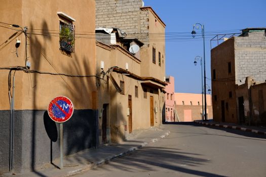 Quiet street in Medina with unique architecture, shadows, and traditional buildings.