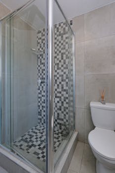 Stylish bathroom featuring a glass shower and tiled floor with checkered design.