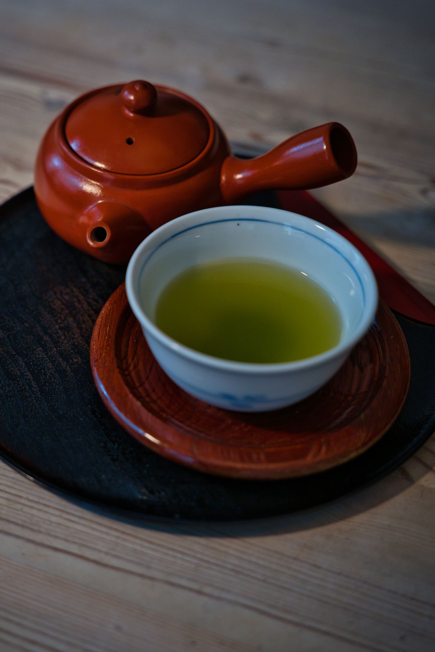 Green tea served with a traditional teapot on a tray.