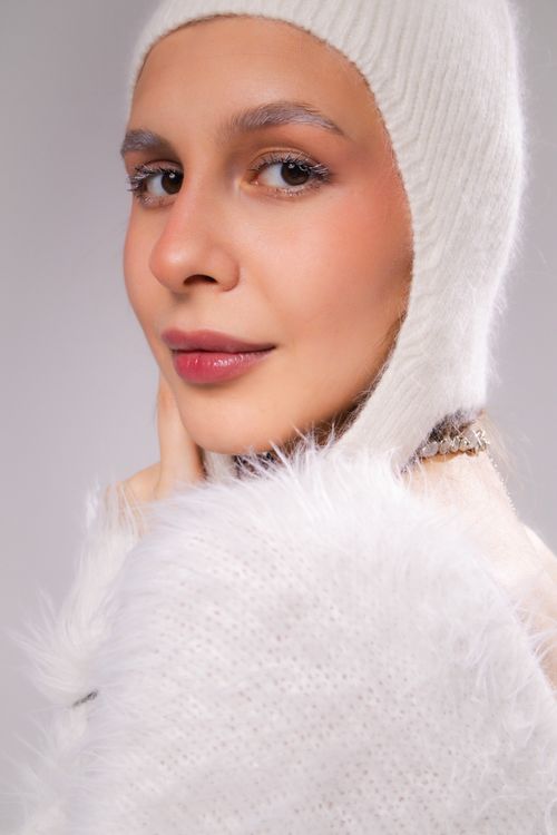 Free Close-up portrait of a woman in fuzzy white winter hat and coat, exuding warmth and elegance. Stock Photo