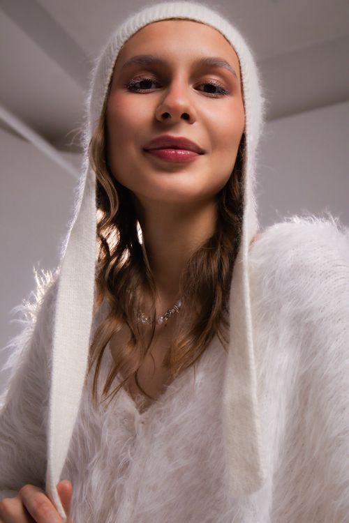 Free Smiling young woman wearing a warm hat and sweater, indoors. Stock Photo