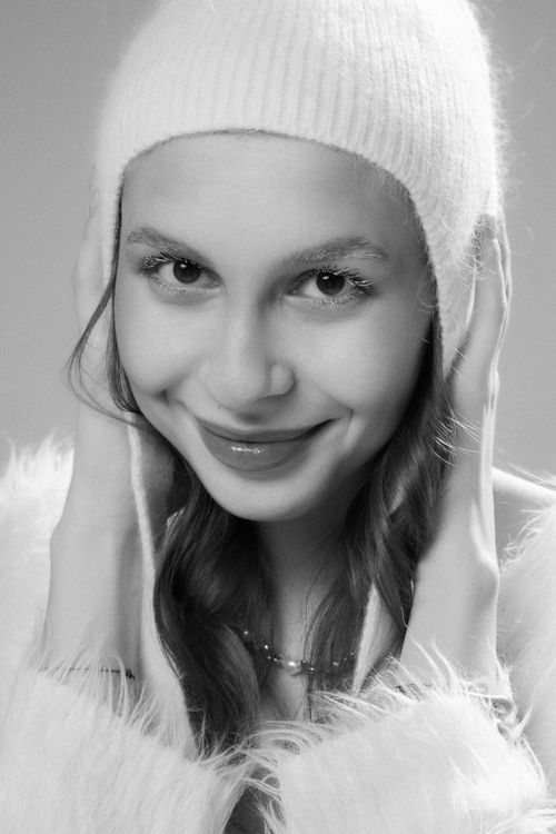 Free Black and white portrait of a woman smiling in a cozy winter hat. Stock Photo