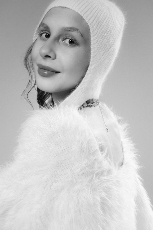 Free Stylish black and white portrait of a woman in a cozy, furry outfit and knit hat. Stock Photo