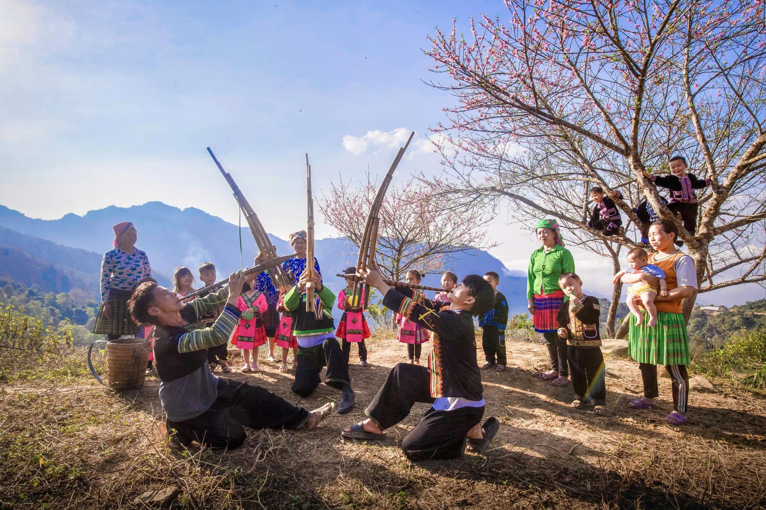 Group enjoying traditional music and dance in a scenic mountainous landscape.