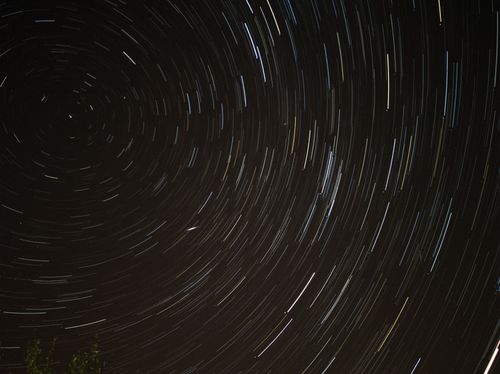 Free A mesmerizing long exposure shot of star trails in the night sky, showcasing astronomical beauty. Stock Photo