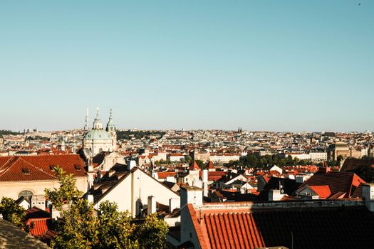Captivating view of Prague's iconic red rooftops and historic skyline under a clear blue sky.