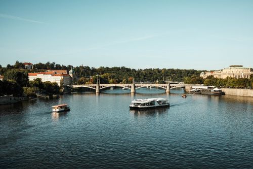 Free Beautiful view of the Vltava River with boats and historical architecture in Prague, Czechia. Stock Photo