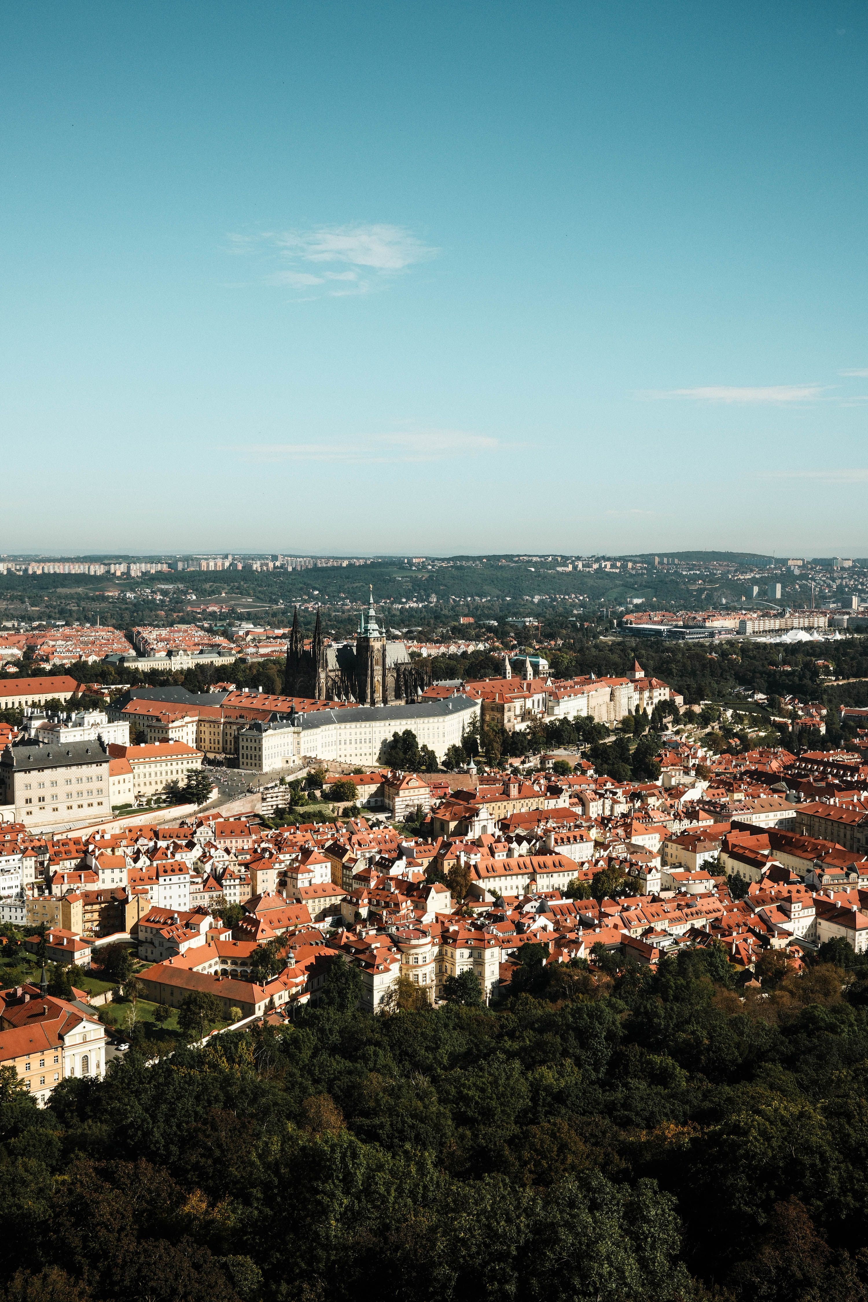 Aerial view of historic Prague cityscape with red rooftops and the castle