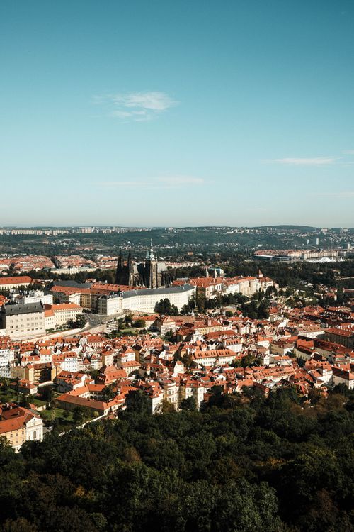 Free Stunning aerial view of Prague's historic cityscape, featuring iconic architecture and landmarks under a clear blue sky. Stock Photo