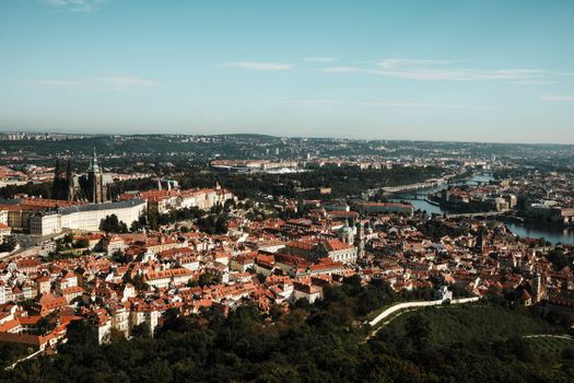 Stunning aerial view of Prague's historic architecture and scenic river on a clear day.