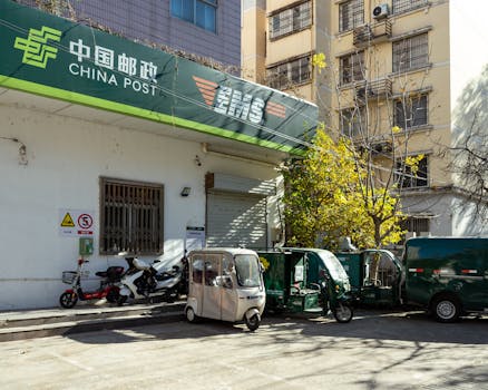 China Post office facade with delivery vehicles in Luoyang, Henan, China.