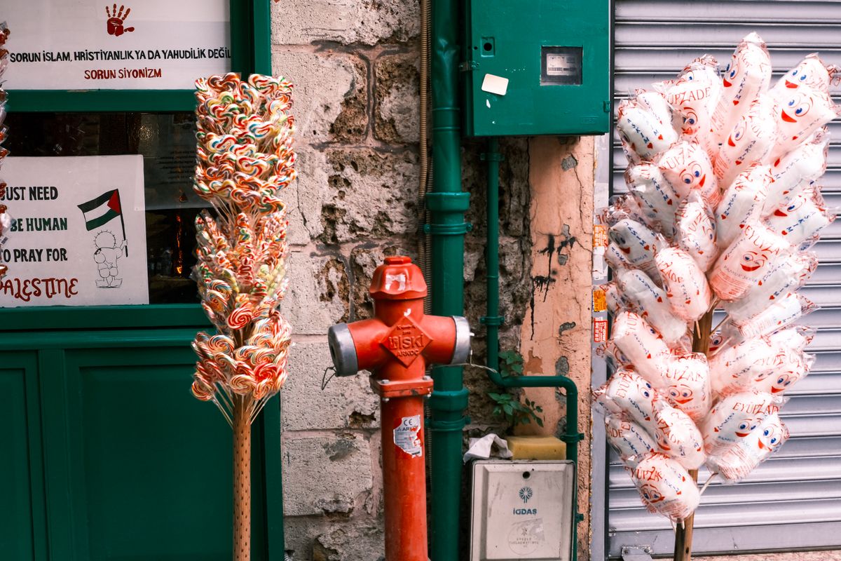 Outdoor street scene featuring a vibrant candy display and balloons near a fire hydrant.