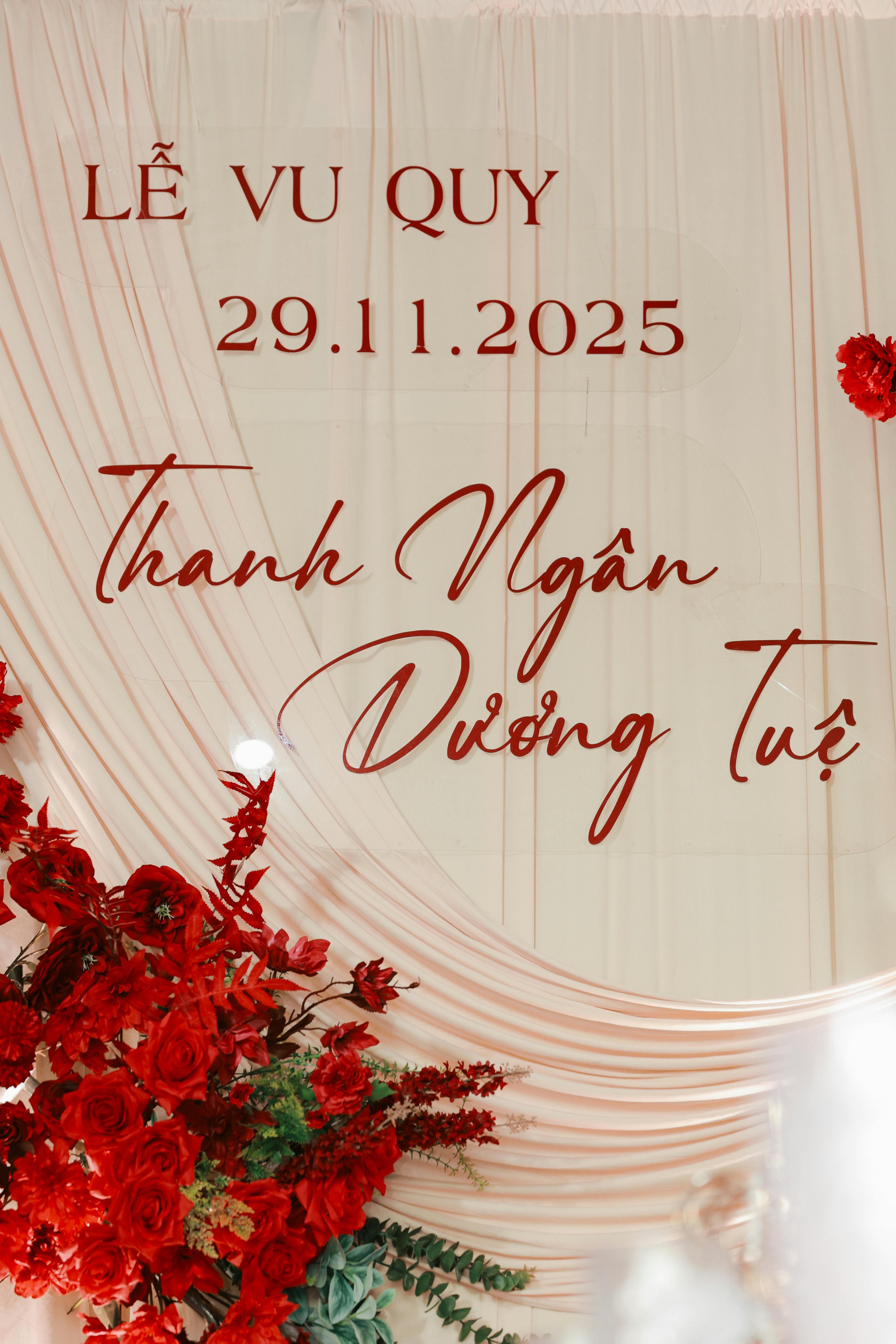 Beautiful red and white wedding backdrop with date and floral decor.