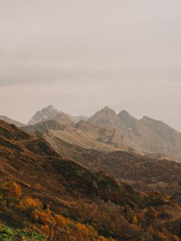 Beautiful autumn landscape with majestic mountains under cloudy sky.