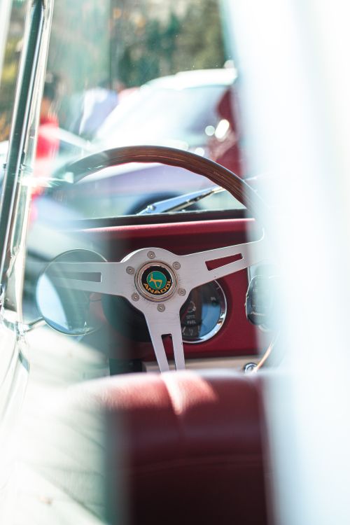 Free Interior view of a classic car featuring a wooden steering wheel and classic dashboard. Stock Photo