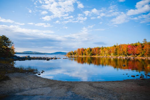 Immagine del fogliame autunnale che si riflette nelle acque tranquille del lago Steuben, nel Maine, e che mette in risalto i vivaci colori autunnali.