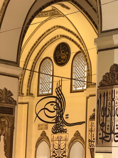 Free Beautiful Islamic calligraphy adorning the interior walls of a historic mosque. Stock Photo