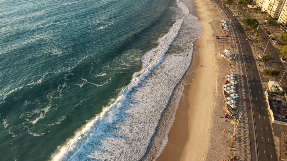 Stunning aerial view of Copacabana Beach showcasing golden sunlight and vibrant waves.