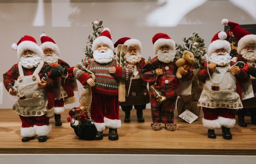 Free Festive collection of Santa Claus figurines arranged on a shelf with Christmas decorations. Stock Photo