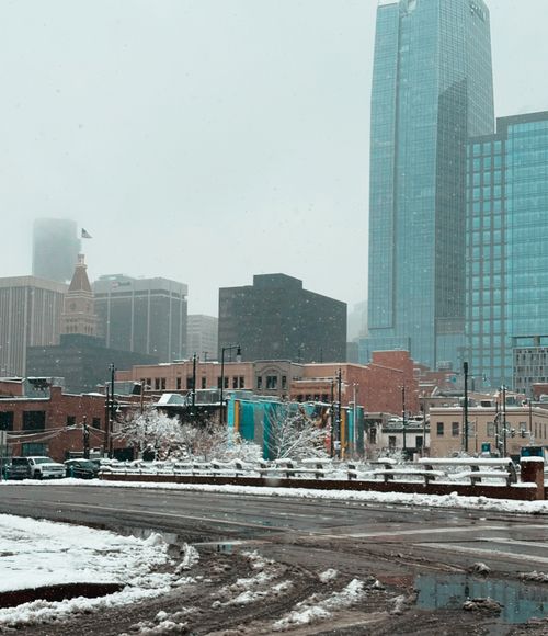 Free Cityscape featuring snow-covered streets and towering skyscrapers on a cold winter day. Stock Photo