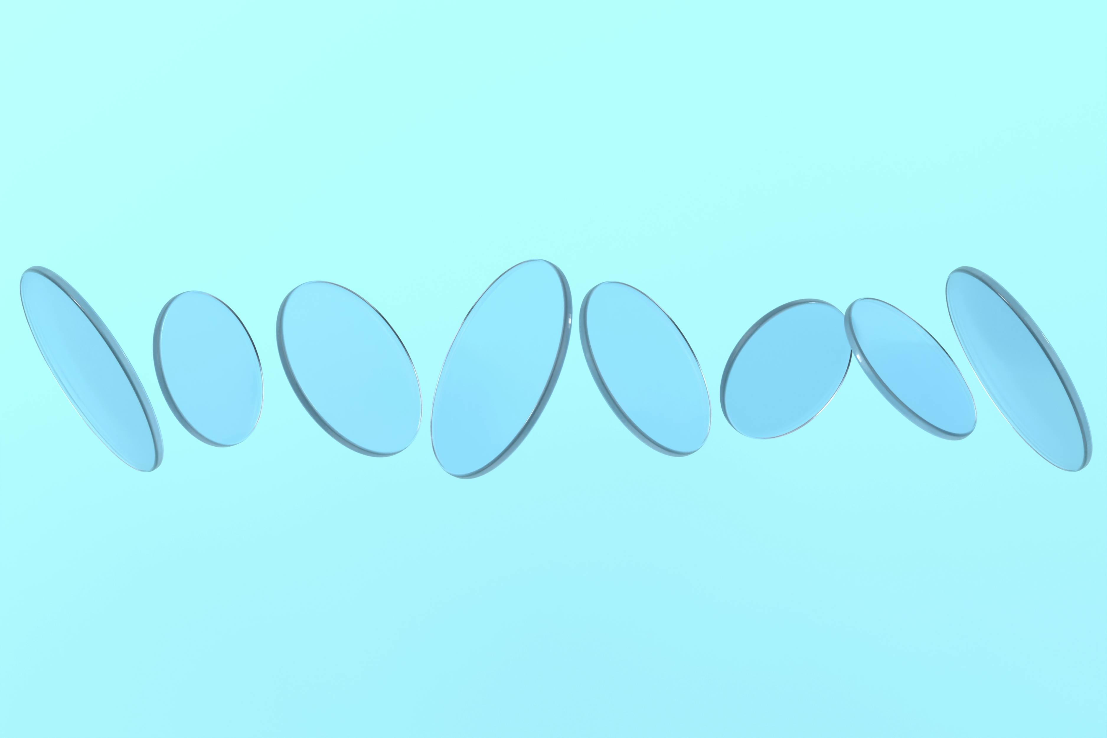 Free Abstract arrangement of transparent blue glass discs floating against a pastel blue backdrop. Stock Photo