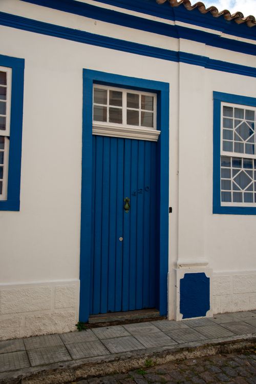 Free Traditional blue door and white facade in colonial Laguna, Brazil showcasing historic architecture. Stock Photo