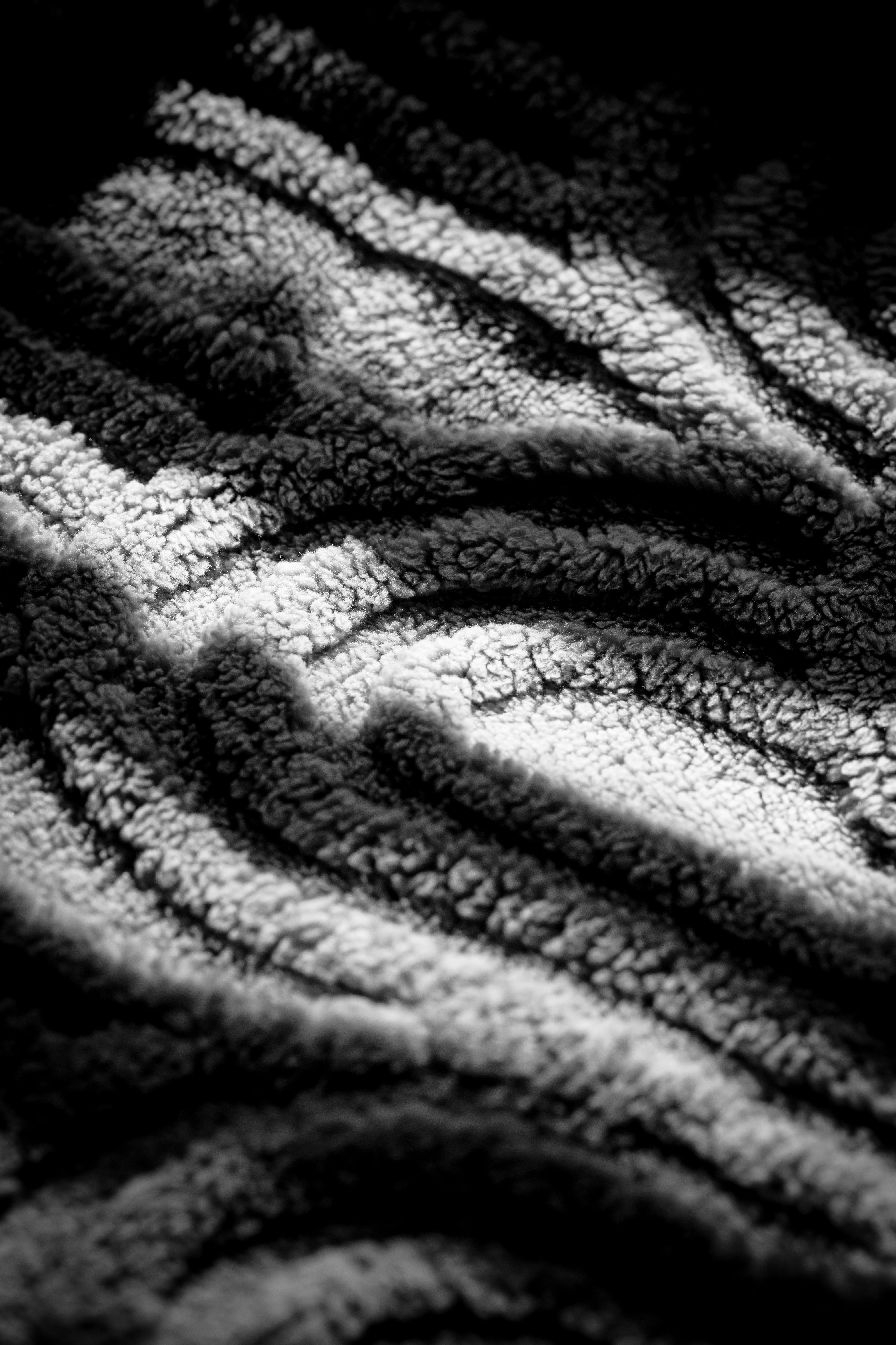 免費 一張細緻的黑白特寫照片，展現了紋理豐富的織物，突出了陰影和高光。 圖庫相片