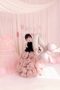 A charming pink-themed birthday party with a young girl holding a number four balloon.
