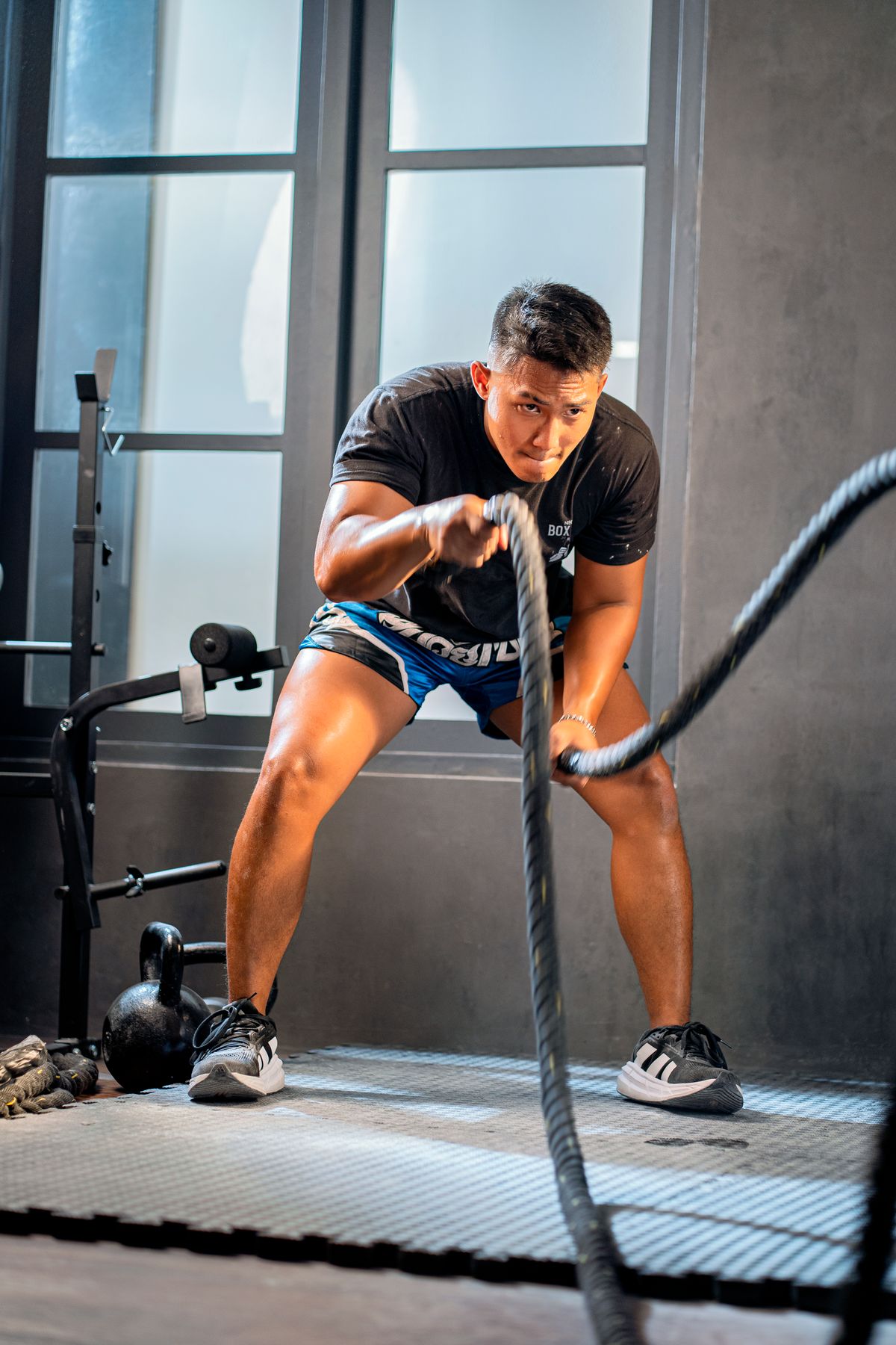 Athlete performing battle rope training inside a gym