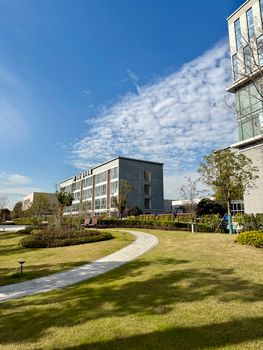 A modern office complex with green lawns and clear skies in Shanghai, showcasing urban development.
