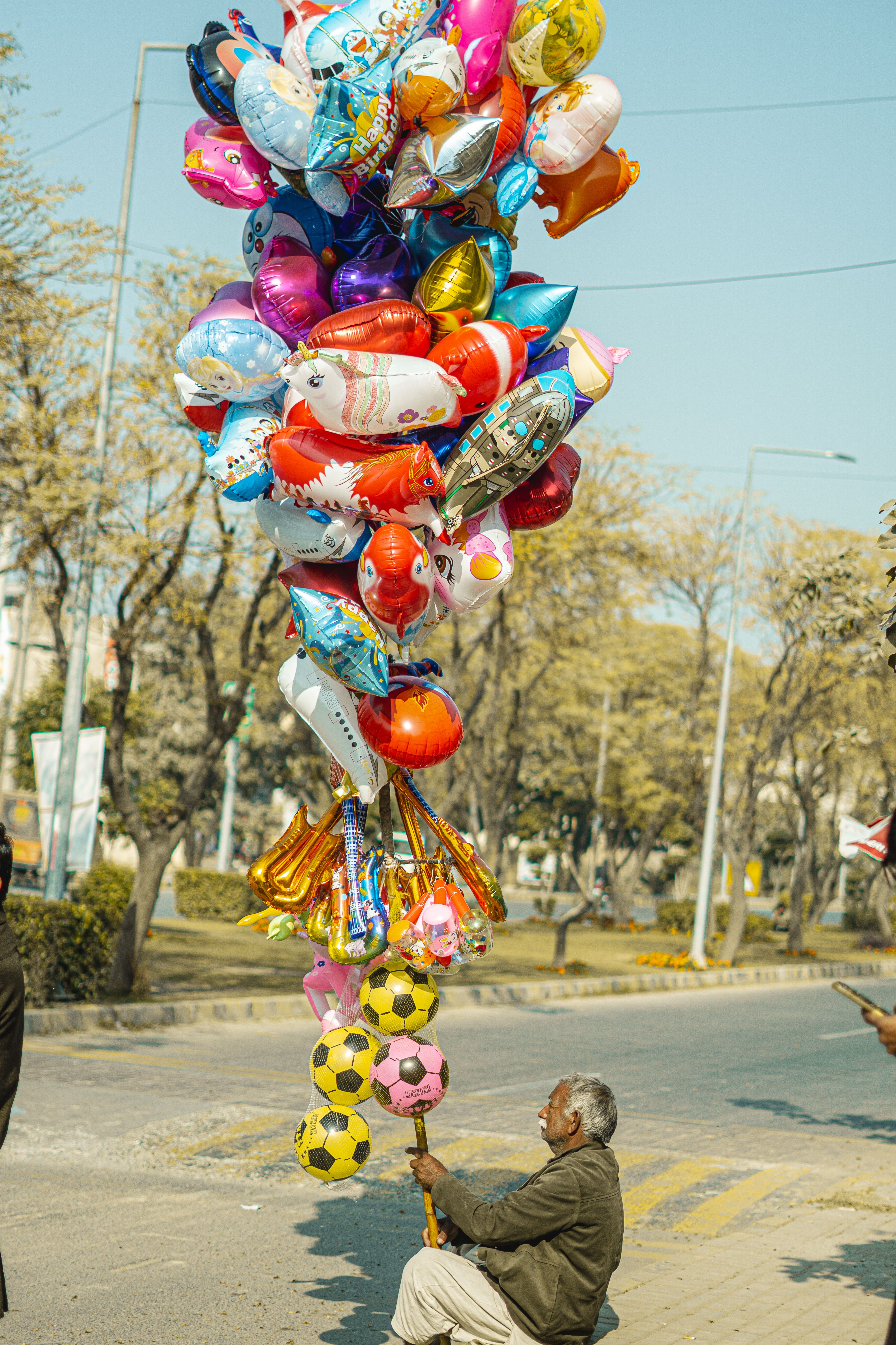 Street Vendor with Colorful Balloons in Urban Setting · Free Stock Photo
